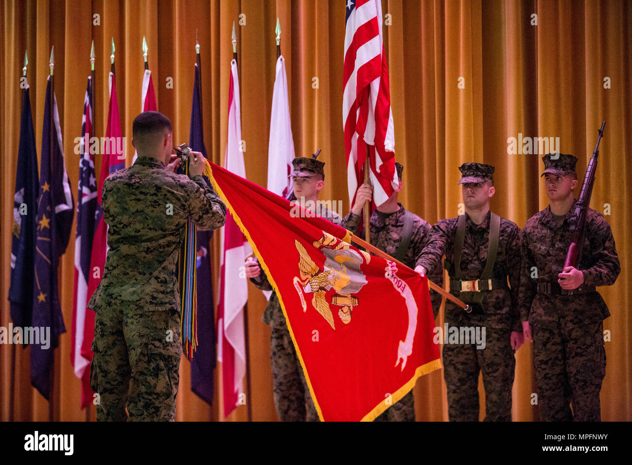 U.S. Marine avec 3D Marine Division, 4e Régiment de Marines attache une bataille pour l'unité de banderoles guidon au cours du 4e Régiment de Marines 103couleurs bataille reconsécration et cérémonie de remise des prix sur le Camp Schwab, Okinawa, Japon, le 9 mars 2017. Des Marines américains, des marins, et des civils ont participé à la cérémonie à réfléchir sur 103 ans de réalisations à partir de 4e Régiment de Marines comme le "plus ancien" et la "fierté" regiment dans le corps à ce jour. (U.S. Marine Corps photo par MCIPAC le Caméra de combat. Jésus McCloud) Banque D'Images