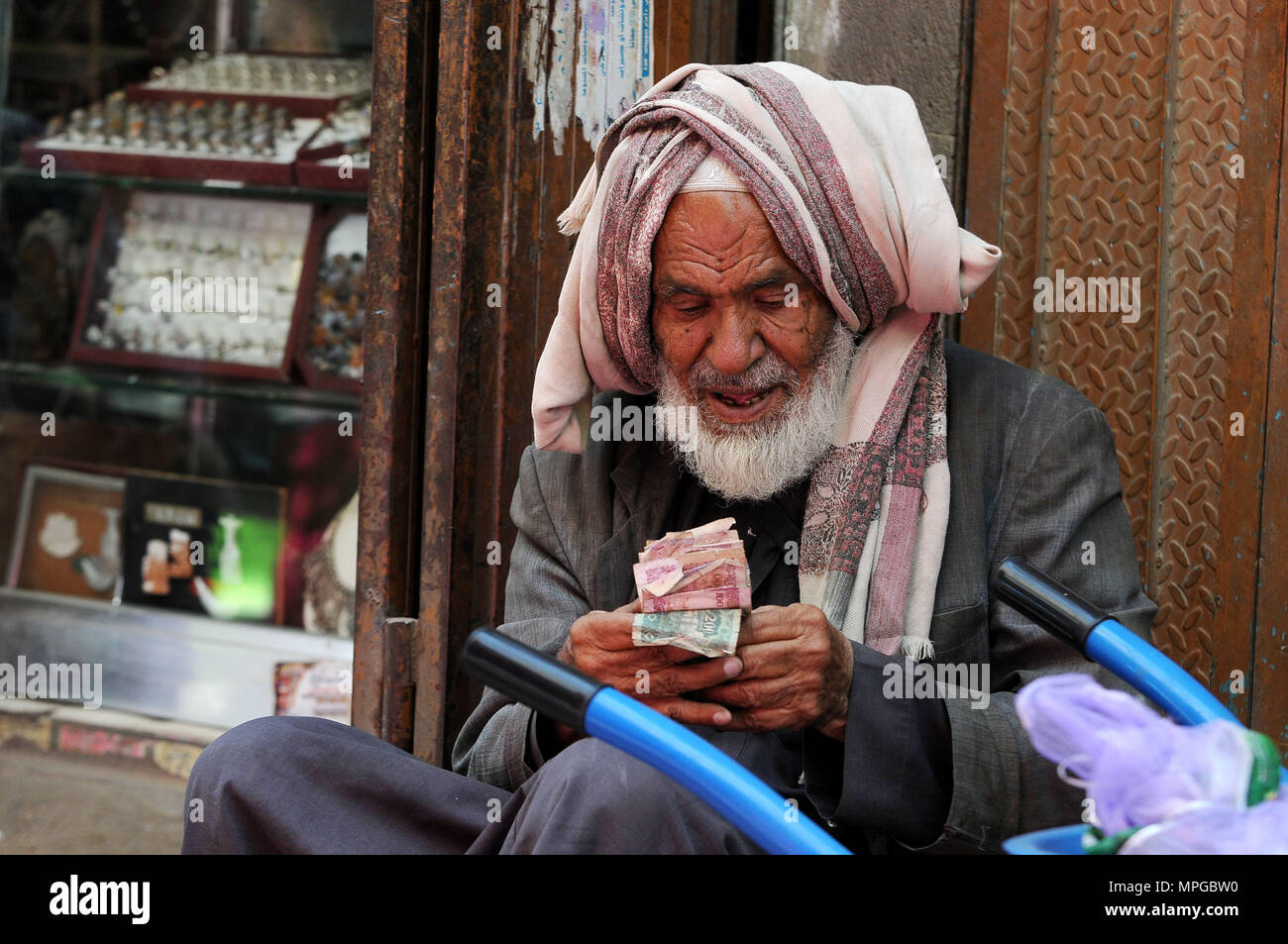 Sanaa, Yémen. 23 mai, 2018. Un homme yéménite compte argent sur le champ dans la vieille ville de Sanaa, Yémen, le 23 mai 2018. Beaucoup de gens au Yémen recevoir ce Ramadan au milieu du désespoir et de dures conditions de vie à la suite des trois années de conflit militaire. Selon les économistes et analystes, Yéménite, le prix des denrées alimentaires est fortement accrue entre 35 pour cent et 100 pour cent dans le cours des derniers mois de 2018, comparativement à la période avant l'intervention militaire dirigée par l'Arabie Saoudite contre l'rebelles Houthi chiites en 2015. Credit : Mohammed Mohammed/Xinhua/Alamy Live News Banque D'Images