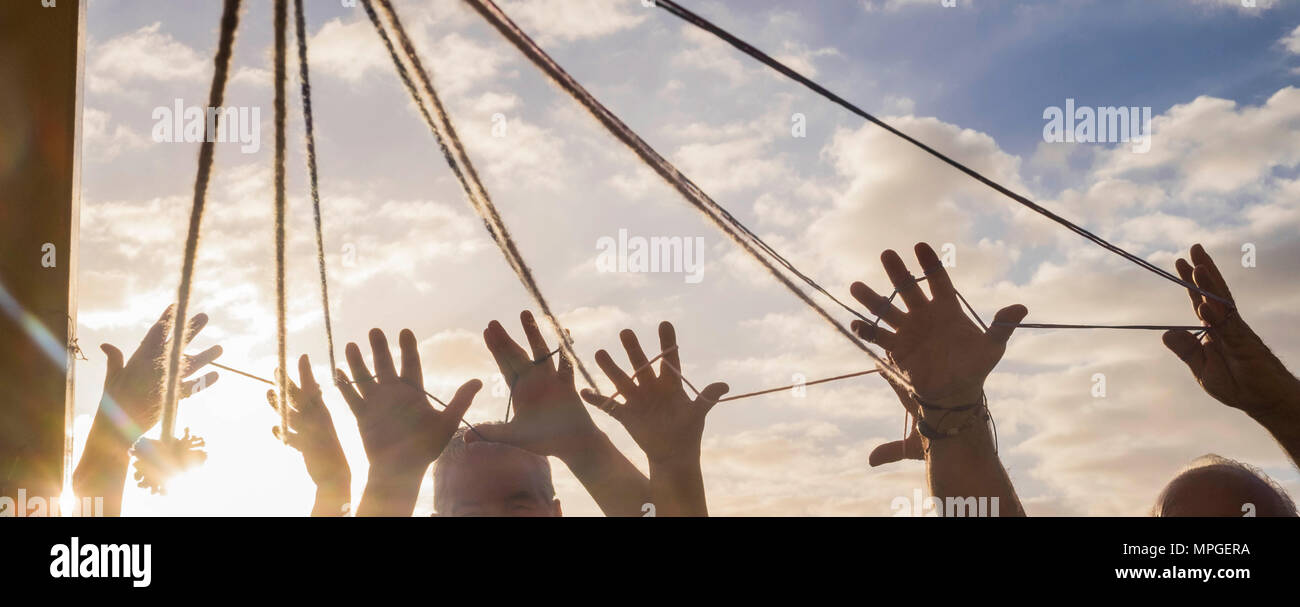 Le travail d'équipe de personnes âgées groupe avec beaucoup de mains united entre un cordon sous le soleil. Tous les mains ensemble avec beau ciel sur l'arrière-plan Banque D'Images