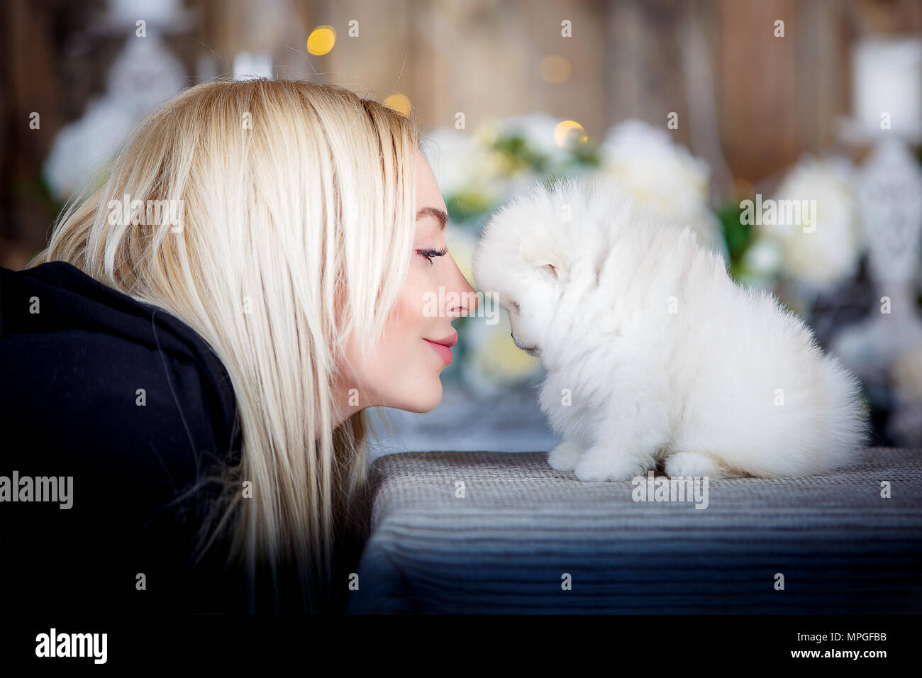 Homme et chien sosie. Belle fille, c'est embrasser un chiot. Le concept de joie, de bonheur et d'amour. Banque D'Images