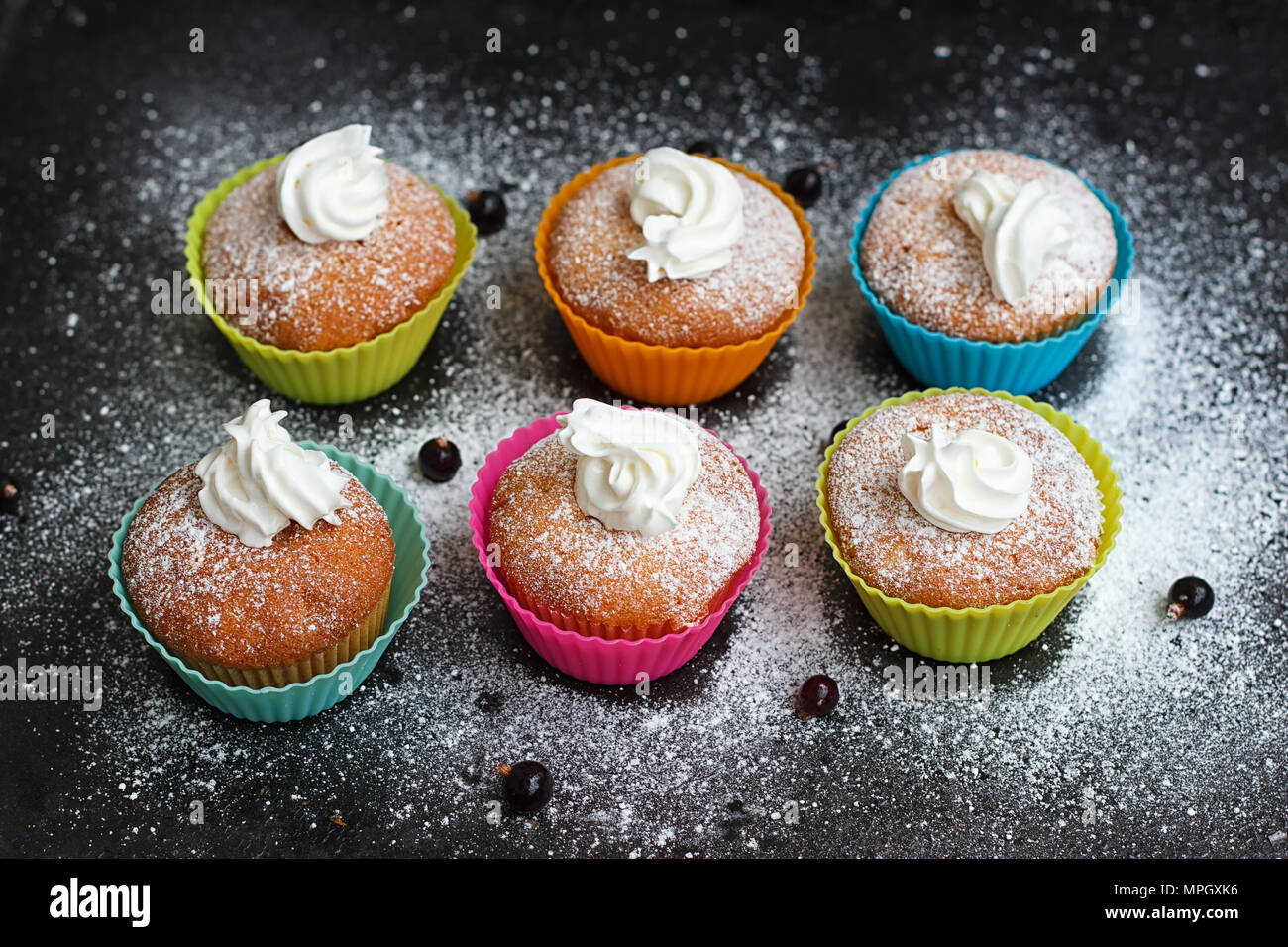 Muffins en silicone colorés formulaires avec crème fouettée Banque D'Images