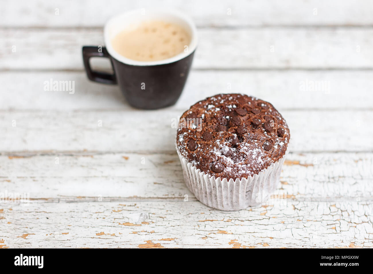 Muffin au chocolat et une tasse de café sur le fond en bois blanc Banque D'Images