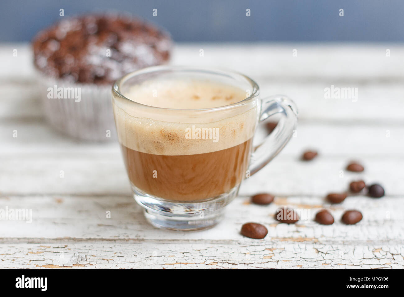 Muffin au chocolat et une tasse de café sur le fond en bois blanc Banque D'Images