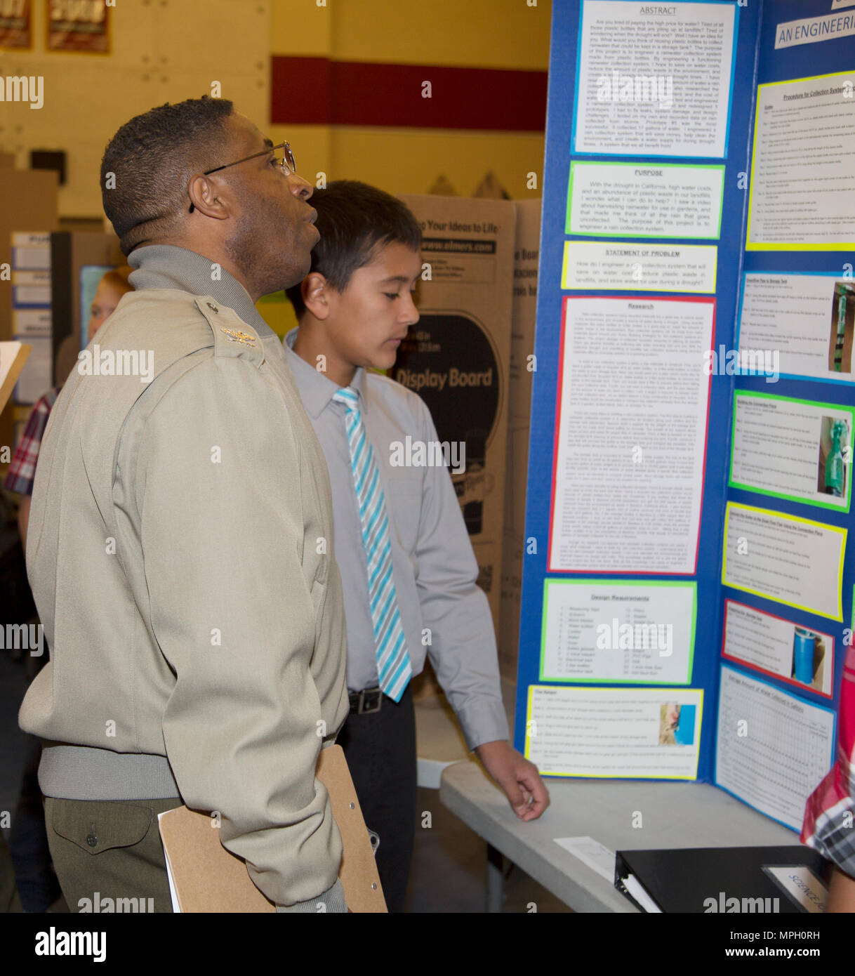 (À GAUCHE) Le Colonel Sékou Karega, commandant de la Base logistique du Corps des Marines, Barstow, Californie ; entretiens avec Jamie Martinez, 13 ans, un élève de l'Académie, à propos de souches Barstow Barstow son Unified School District projet d'Expo-sciences "la collecte or liquide." L'expérience en jeu la réutilisation des bouteilles en plastique pour sauver l'eau de pluie et de réduire la quantité de plastique dans l'environnement. Plusieurs autres Marines du MCLBB a également agi en tant que juges dans la foire, une tradition remontant à plusieurs années. Les organisateurs de l'Expo-sciences BUSD dit qu'ils ont le plus grand nombre d'entrées pour l'événement de la juste's hist Banque D'Images