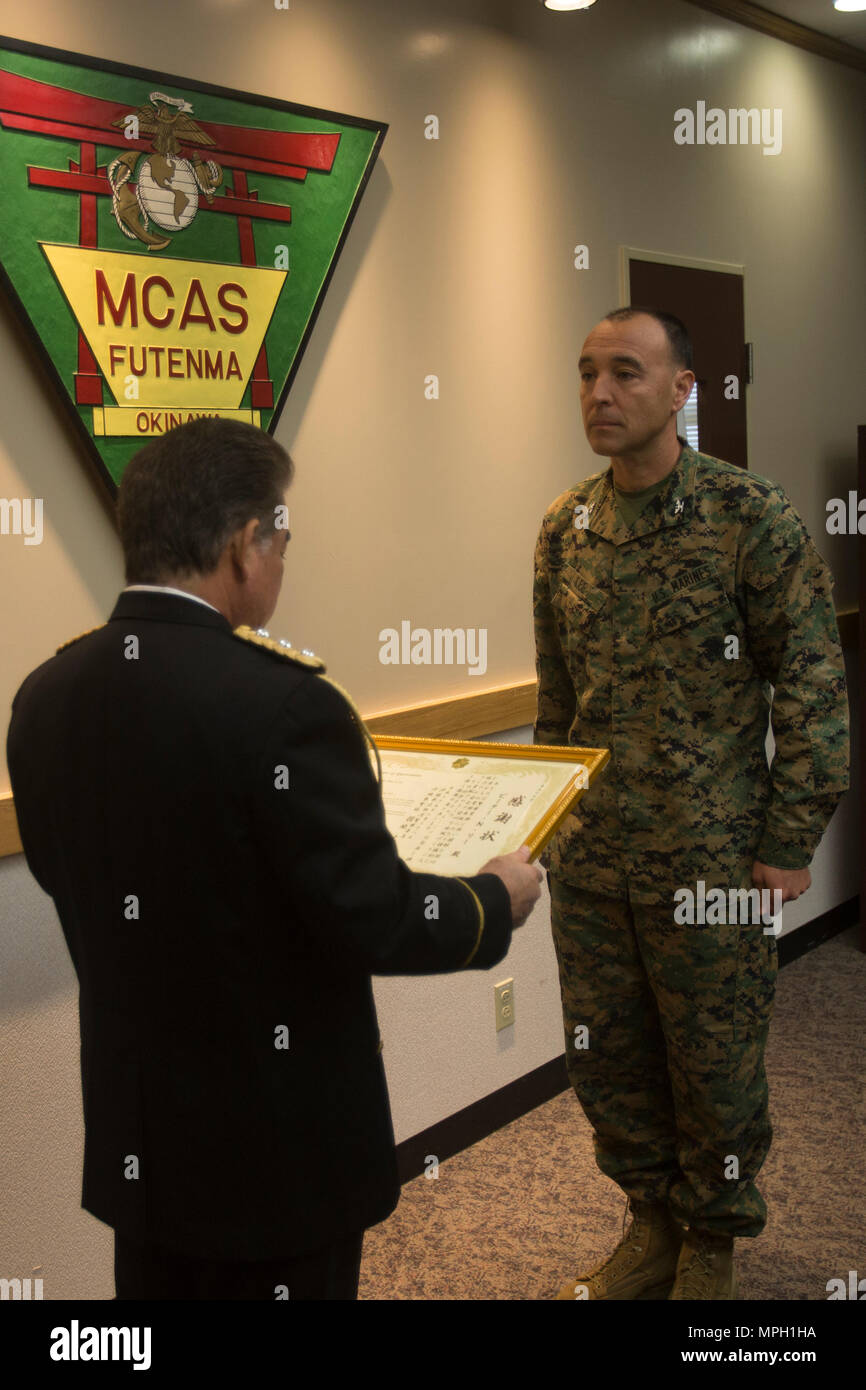 Le chef de la Police de Ginowan Motoki Haneji présente une lettre d'appréciation présentés au Colonel Peter N. Lee le 28 février sur Futenma Marine Corps Air Station, Okinawa, Japon. En tant que commandant de MCAS Futenma, Lee a supervisé divers programmes pour aider les Marines incarnent la devise 'protéger ce que vous avez gagné." "Veuillez continuer votre contribution à Okinawa, les États-Unis, le Japon et le monde", a déclaré Haneji. Banque D'Images