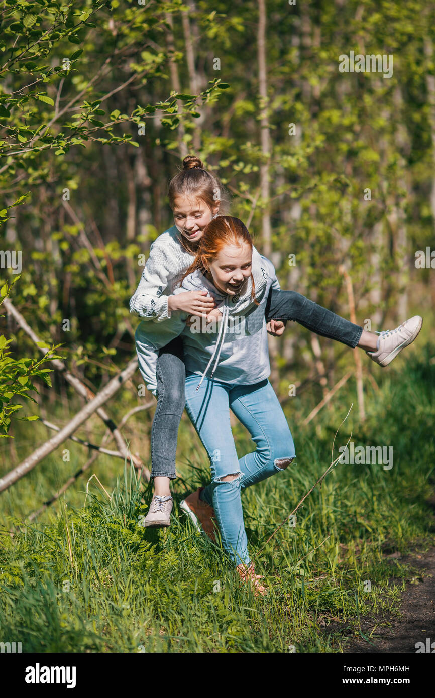 Deux soeurs filles amis adolescents s'amusant dans le parc à l'été. Banque D'Images
