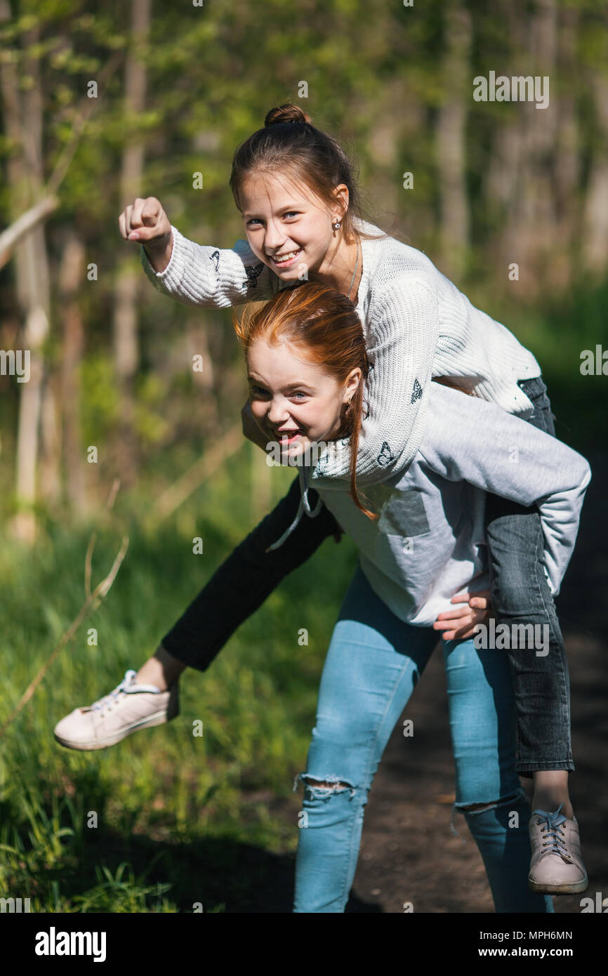 Deux soeurs filles amis adolescents s'amusant dans le parc à l'été. Banque D'Images