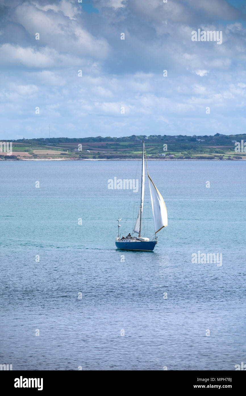 Un voilier sur la mer au large de la côte de Cornouailles. Banque D'Images