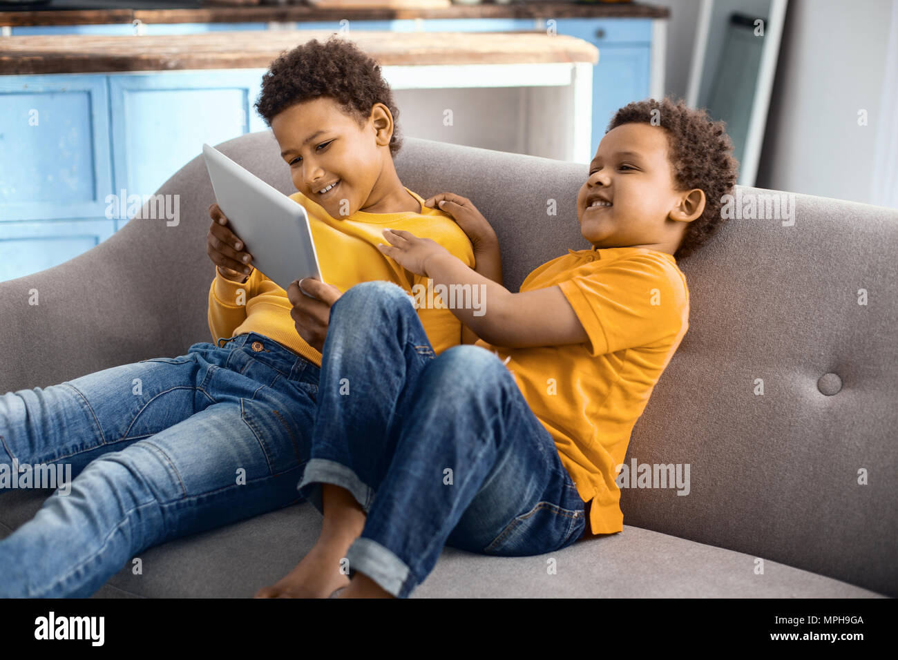 Heureux petits garçons regarder cartoon et rire Banque D'Images