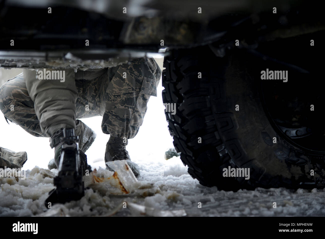 Un aviateurs affecté à la 105e Airlift Wing met un cric sous un Humvee en dehors de Rye, New York le 14 mars 2017. Le Humvee a un pneu à plat au cours de la réponse à la tempête de Stella. (U.S. Photo de l'Armée de l'air par le sergent. Julio A. Olivencia Jr.) Banque D'Images