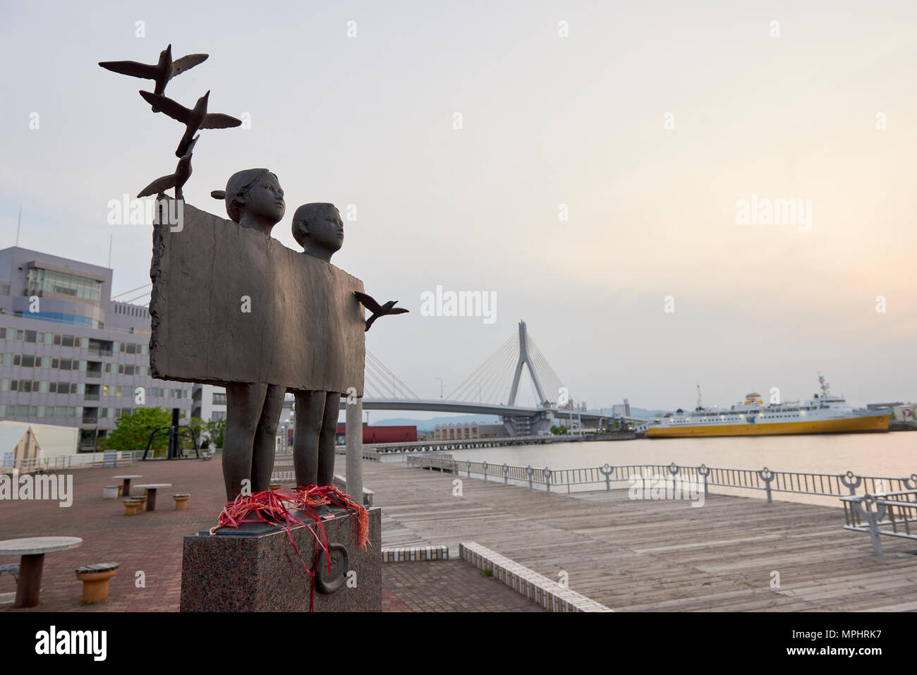 Futari (sens deux personnes) statue Aoiumi Park à Aomori, Japon, avec Aomori Bay Bridge en arrière-plan. Banque D'Images