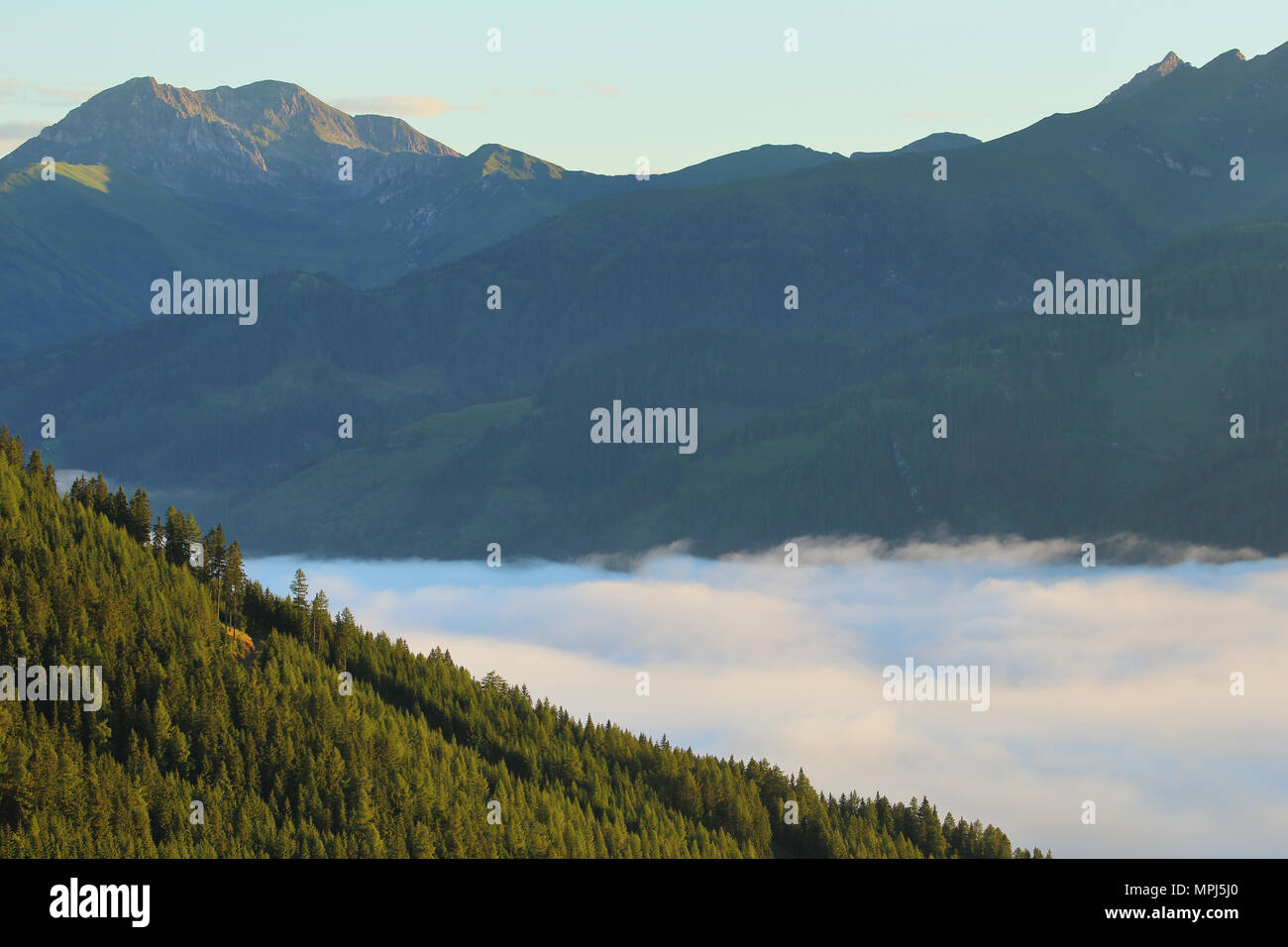 Des sommets alpins et une couverture de nuages dans la vallée à Katschberg en Autriche un matin tôt. Banque D'Images