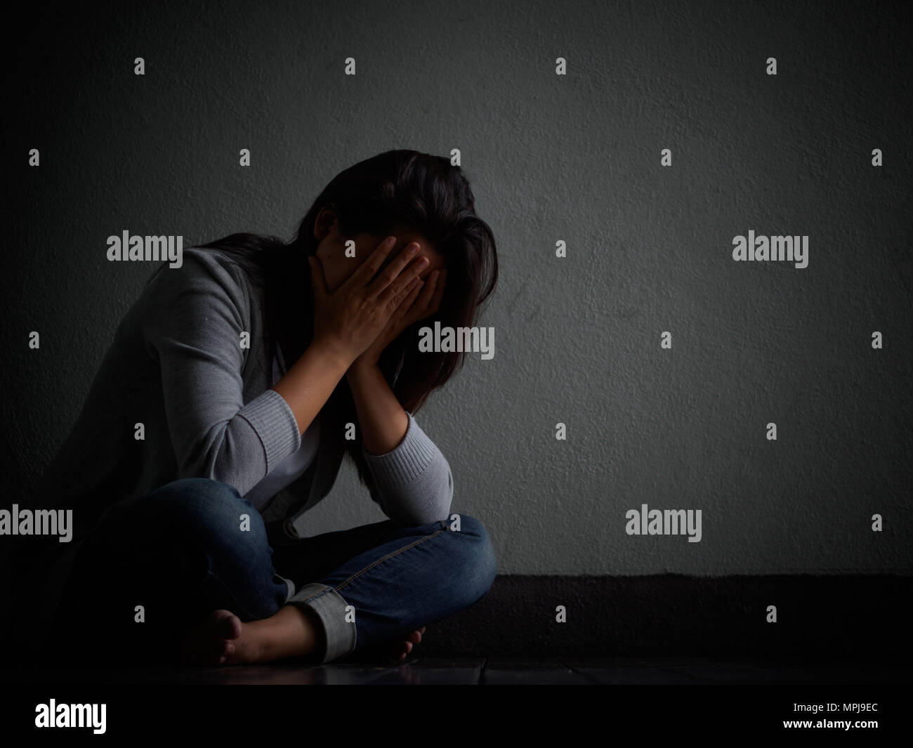 Femme Triste Hug Son Genou Et Pleurer Femme Triste Assise Seule Dans Une Salle Vide Photo Stock Alamy