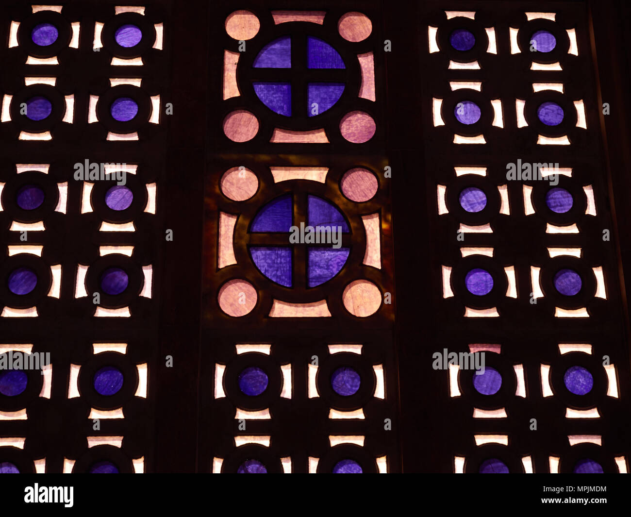 Résumé fond de vitraux lumineux avec du violet et orange sur un mur de verre foncé. Banque D'Images
