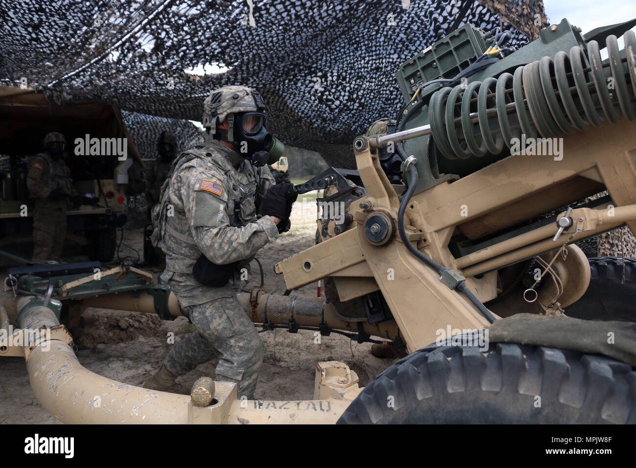 Artilleurs avec batterie Alpha, 1er Bataillon, 9e Régiment d'artillerie, 3ème Division d'infanterie à préparer un feu d'artillerie de 105mm Howitzer cannon le 10 mars 2017 à Fort Stewart, Ga. soldats portaient des masques à gaz pour simuler leurs canons de tir alors qu'ils étaient attaqués avec des armes chimiques au cours des tables d'artillerie du bataillon. 1-9 FA soutient directement l'équipe de combat de la 2e Brigade d'infanterie, 3ème Division d'infanterie en fournissant les feux d'artillerie pour les unités au sol. (U.S. Photo de l'armée par la CPS. Wyatt Davis/libérés) Banque D'Images