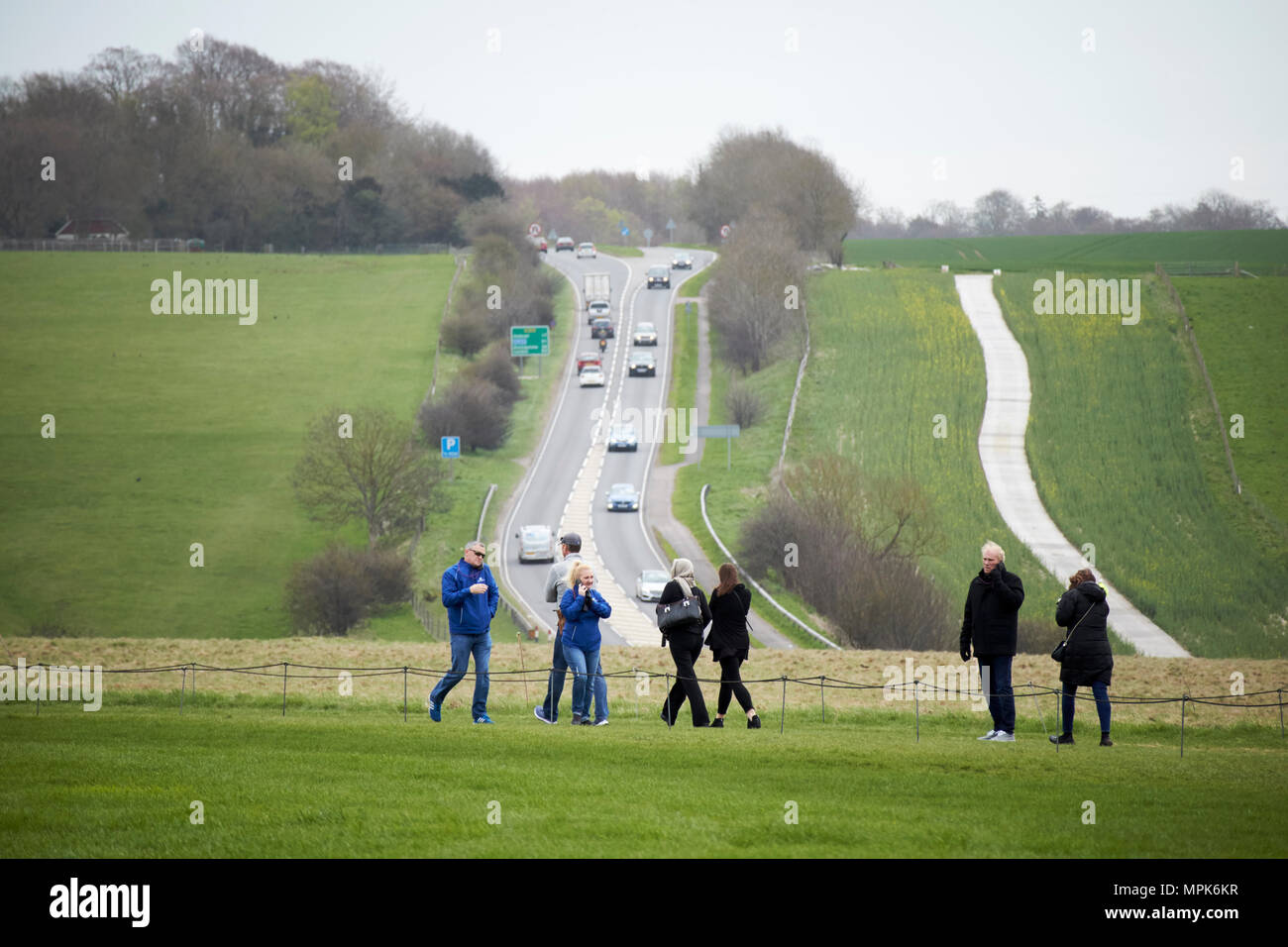Sentier de marche les touristes à Stonehenge l'écoute audio guide devant occupé a303 wiltshire england uk Banque D'Images