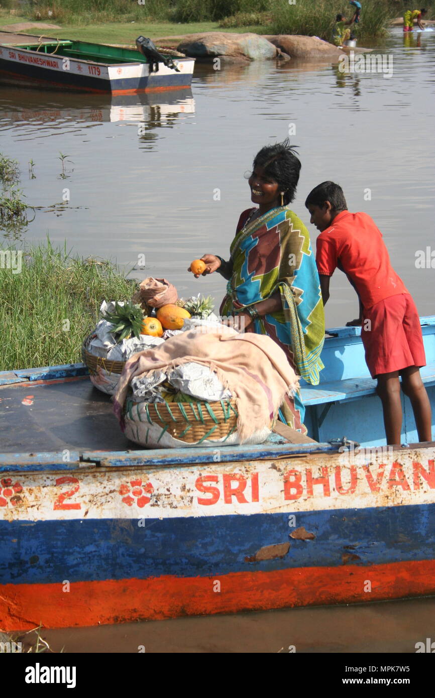 Smiling Indian Lady avec des fruits dans le panier sur le bateau, Hampi, Inde Banque D'Images