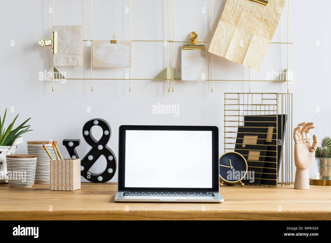 Maquette de l'ordinateur portable sur un bureau en bois avec horloge, plantes et pots à l'intérieur de l'espace de travail Banque D'Images
