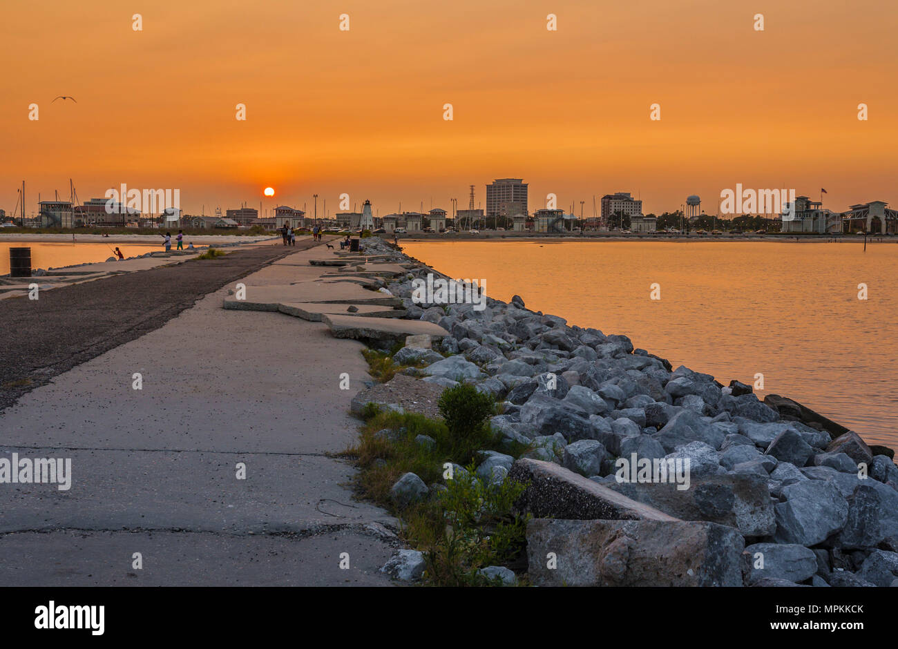 Des dalles de béton brisées sur la jetée de roche au coucher du soleil dans la marina municipale de Gulfport à Gulfport, Mississippi Banque D'Images
