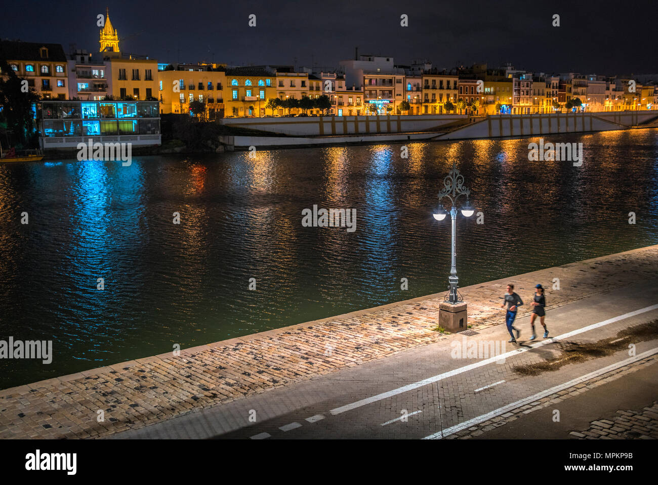Couple running par la rivière, Séville, Espagne Banque D'Images
