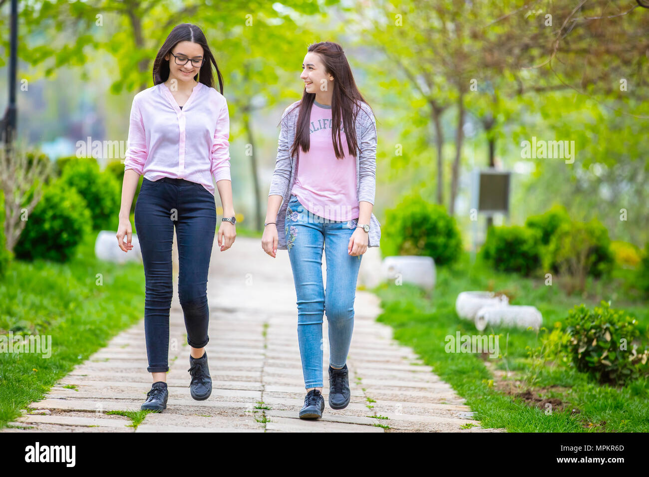 Deux jolies soeurs filles marcher et s'amuser ensemble dans le parc au printemps. Banque D'Images