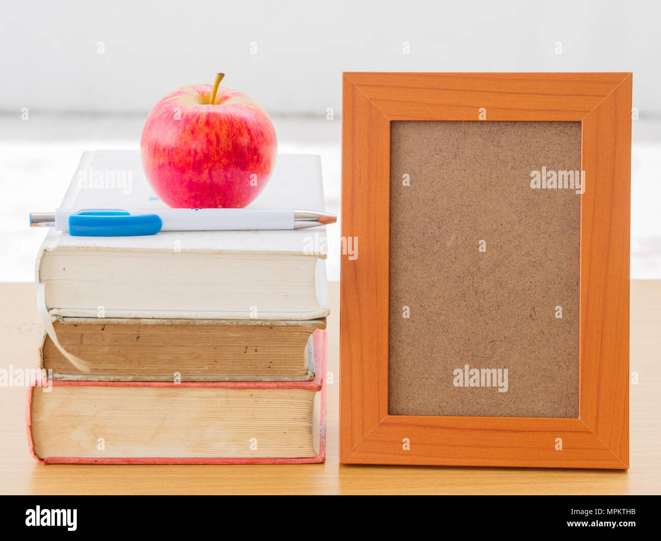 Concept de la Journée mondiale du livre. Pomme Rouge et stylo mis sur de vieux livres avec photo frame Banque D'Images