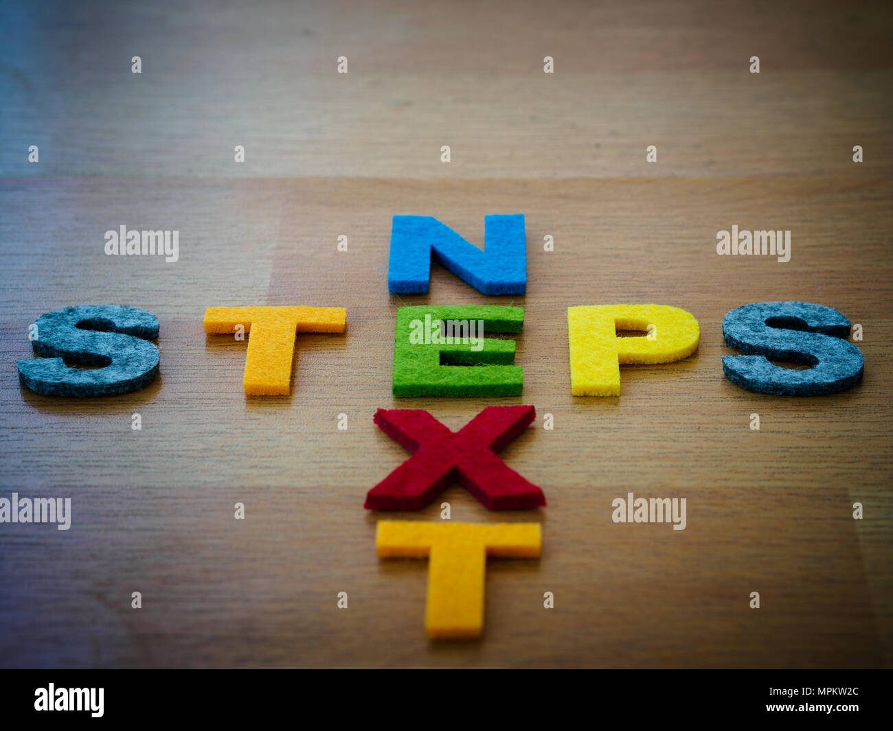 Prochaines étapes concept en lettres colorées sur tableau noir en bois Banque D'Images