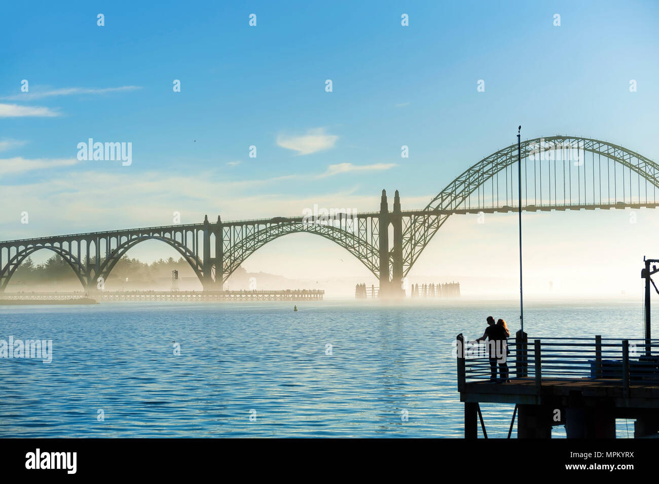 Newport, Oregon, USA - Le 25 janvier 2015 : Silhouette d'un couple à la fin de la jetée à contempler la vue de l'Yaquina Bay Bridge à Newport, sur la th Banque D'Images