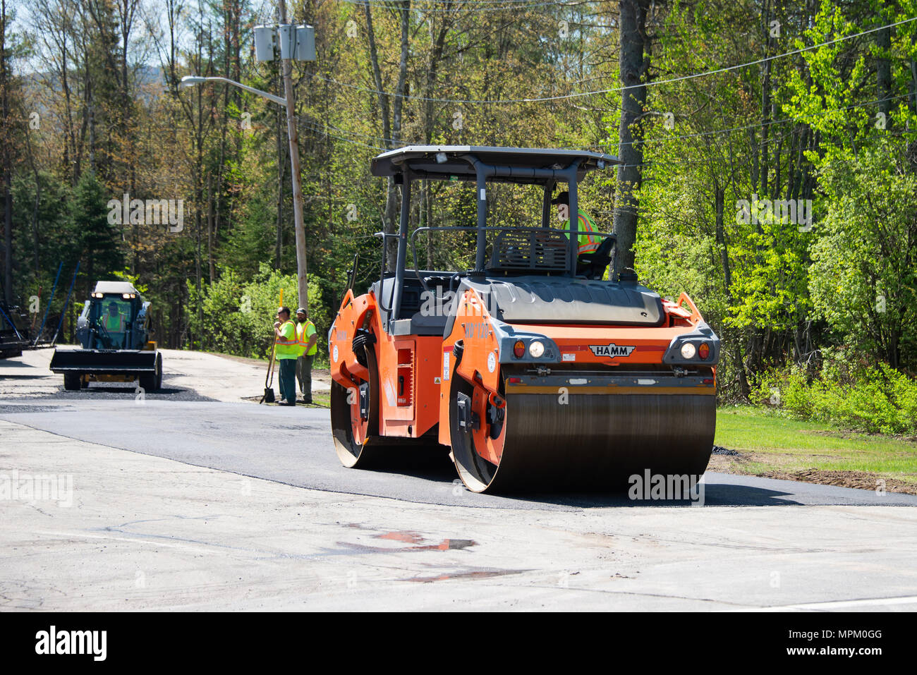 Un rouleau compresseur, ou un rouleau compacteur, compactage de l'asphalte dans un parking de spéculateur, NY USA Banque D'Images