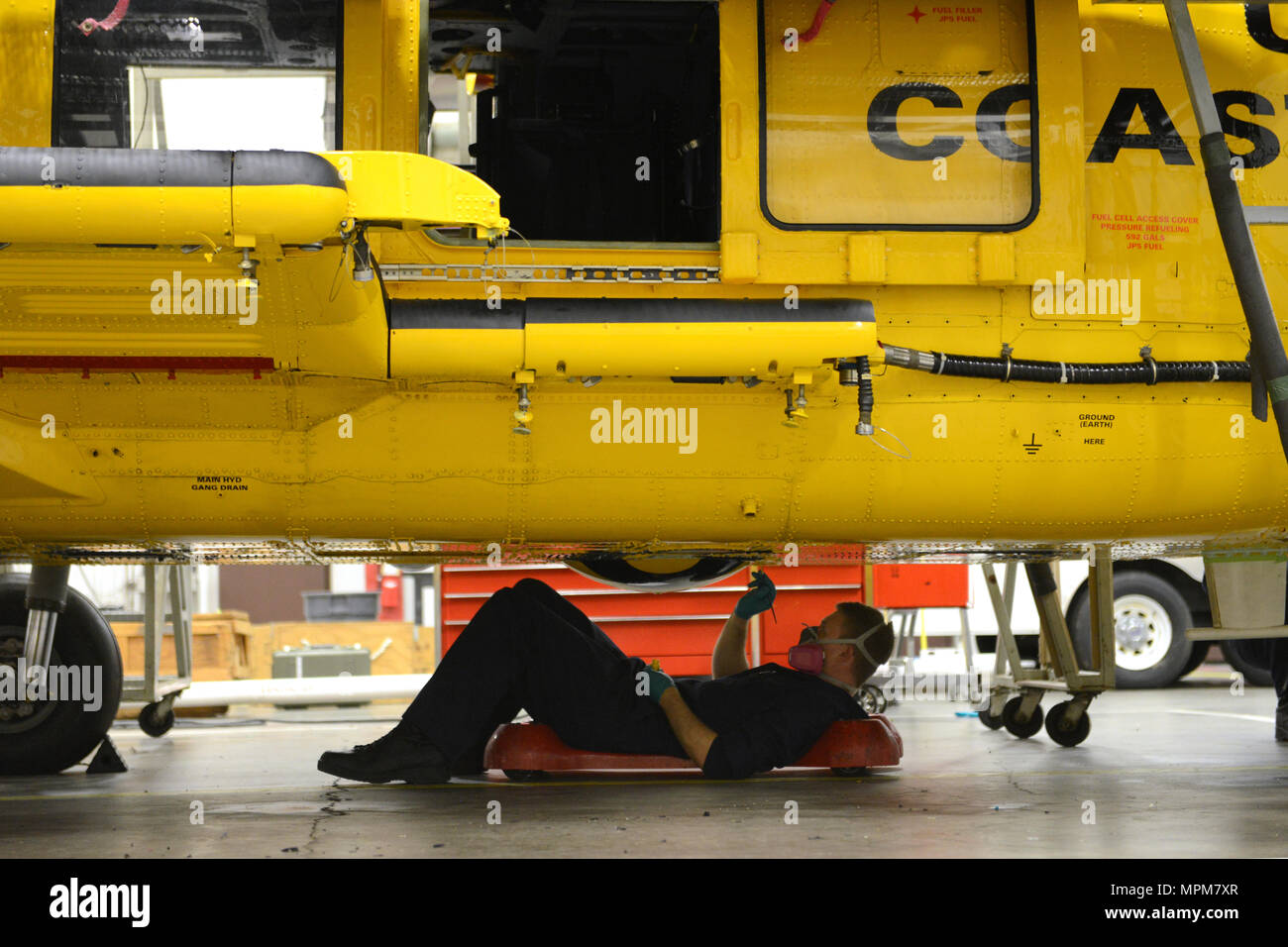 Maître de 3e classe Sam Potter, un technicien de maintenance, l'aviation effectue l'entretien anti-corrosion sur un hélicoptère Jayhawk MH-60 dans le hangar au secteur de la Garde côtière canadienne dans la rivière Columbia Warrenton, Oregon, Mars 26, 2017. Ce n'est qu'une des nombreuses tâches effectuées pendant cette période de maintenance. U.S. Coast Guard photo de Maître de 1re classe Zac Crawford. Banque D'Images