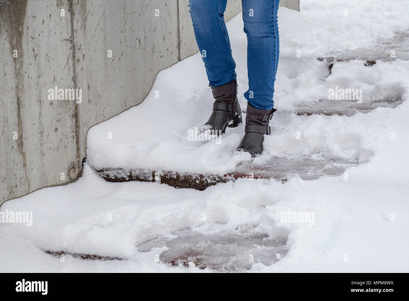 Les jambes des femmes porter des bottes en descendant les escaliers sur sentier enneigé en hiver. Banque D'Images