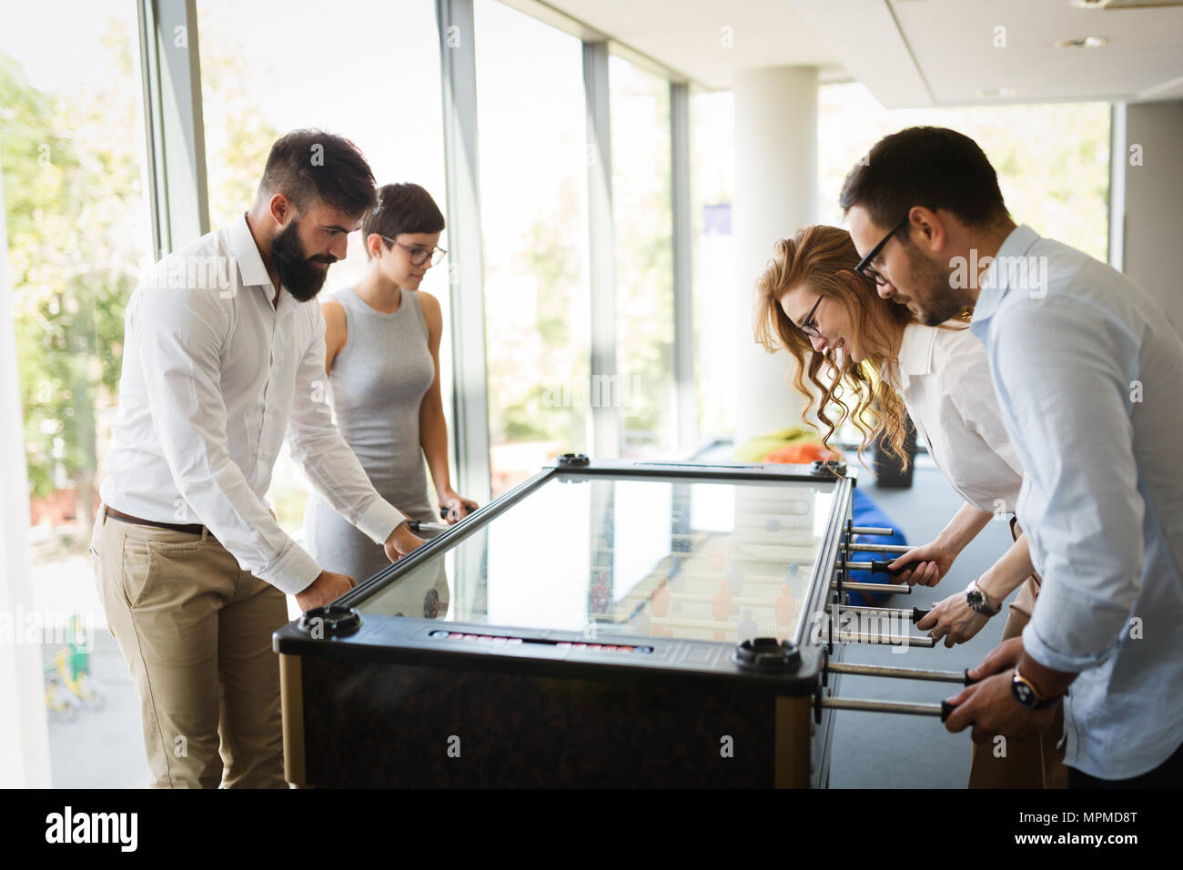 Collaborateurs playing table football sur pause du travail Banque D'Images