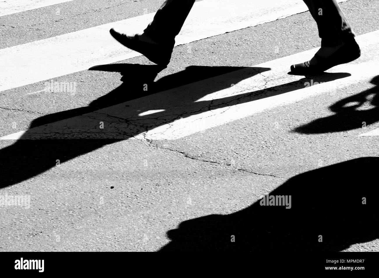 Rue de la ville floues avec passage piétons piétons en marche silhouettes et ombres en noir et blanc de contraste élevé Banque D'Images