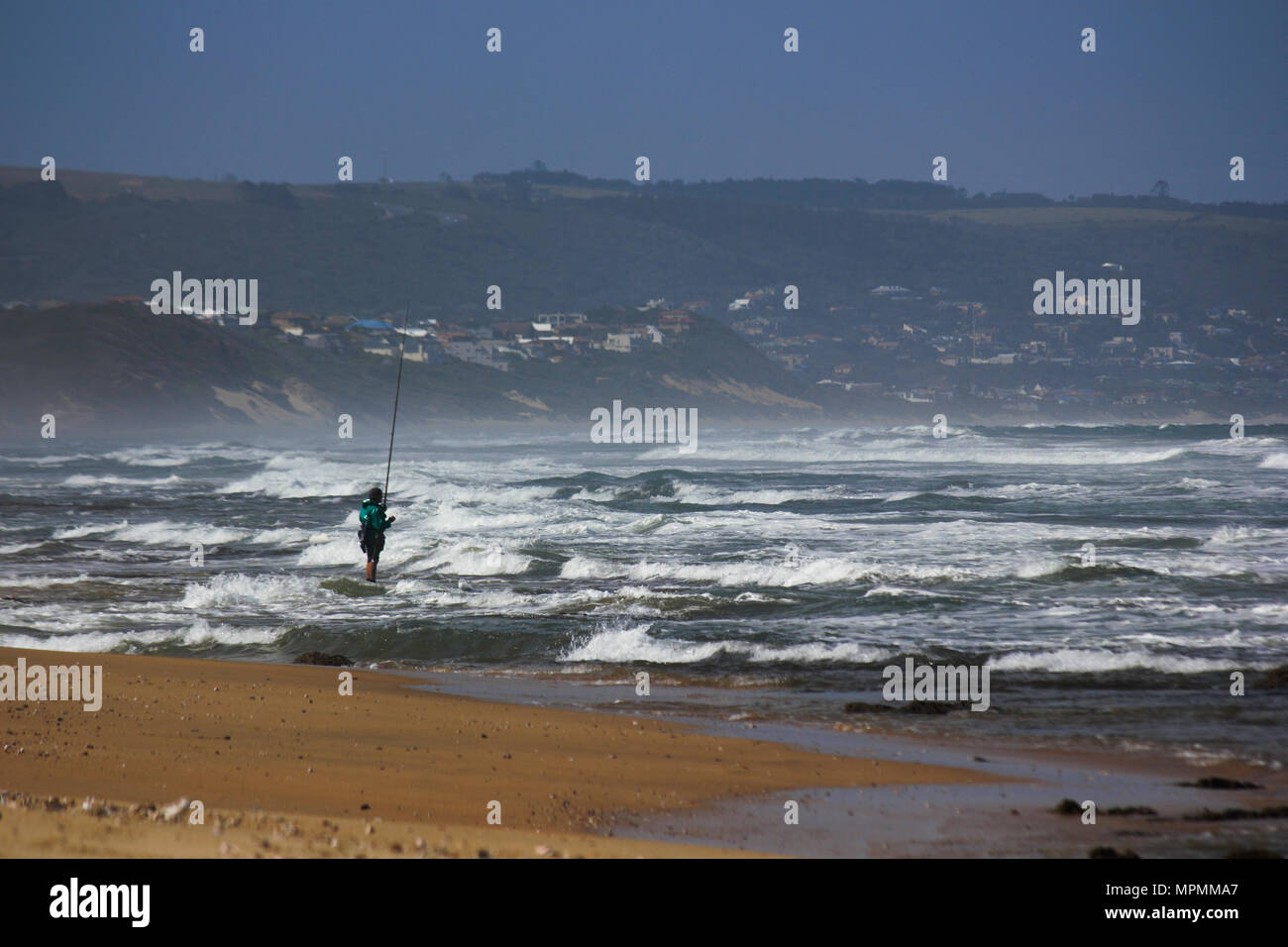 Pêcheur debout dans le Shore Break Banque D'Images