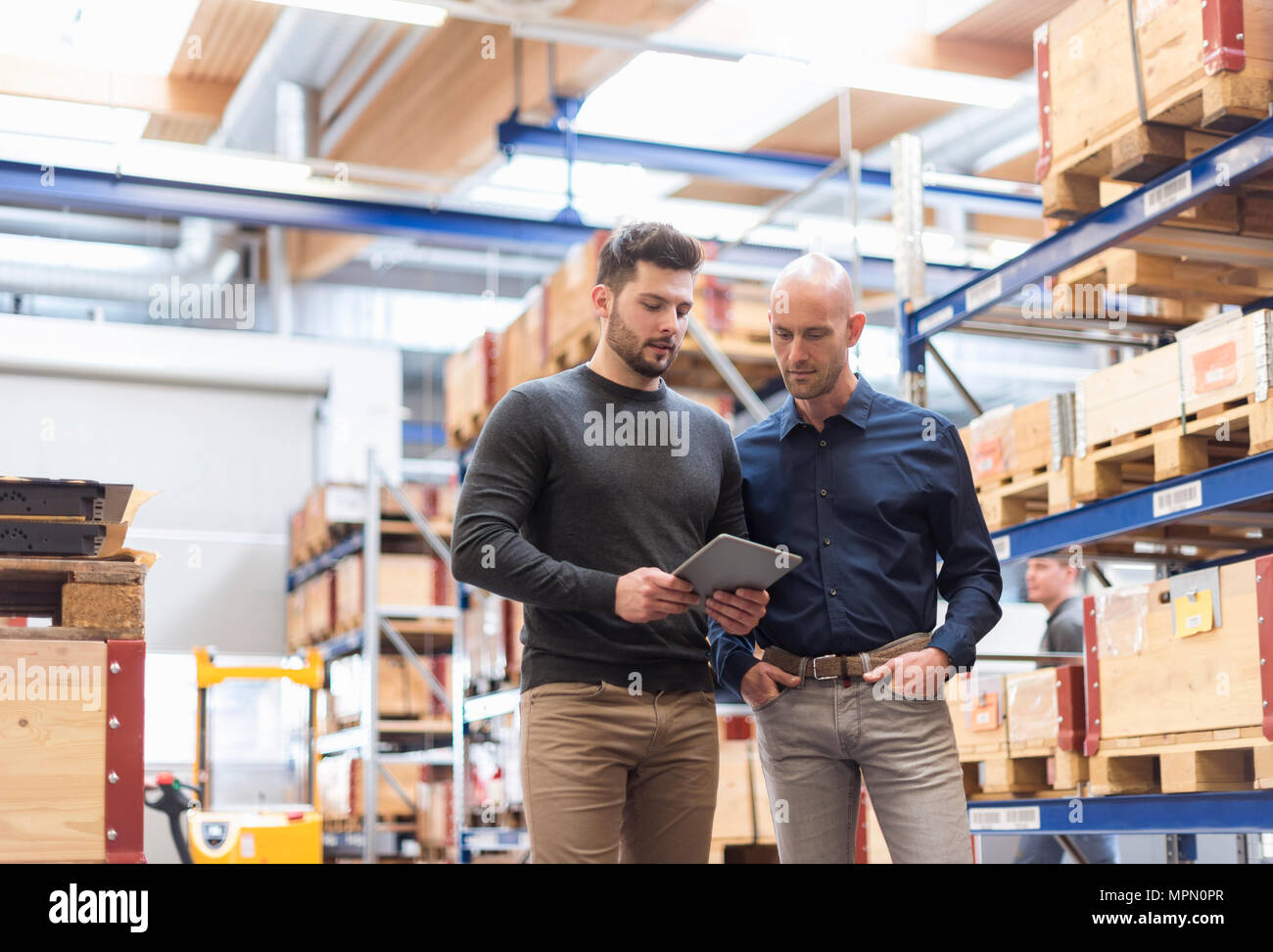 Deux hommes parlant de tablettes en magasin d'usine Banque D'Images
