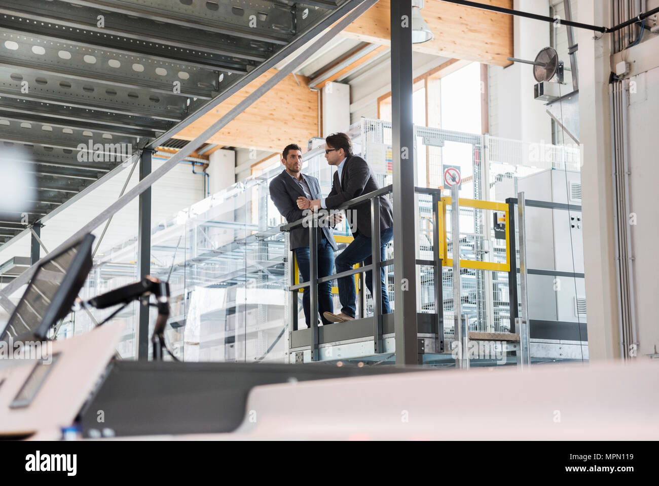 Deux businessmen talking in modern factory Banque D'Images