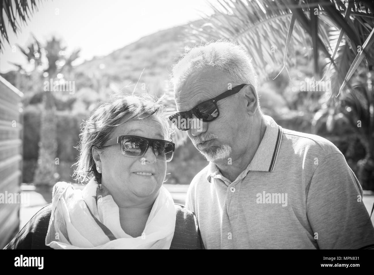 Couple âgé avec des cheveux blancs et lunettes de jouer et grimaces à l'extérieur l'été Banque D'Images Couple âgé avec des cheveux blancs et lunettes de jouer et grimaces à l'extérieur l'été Banque D'Images