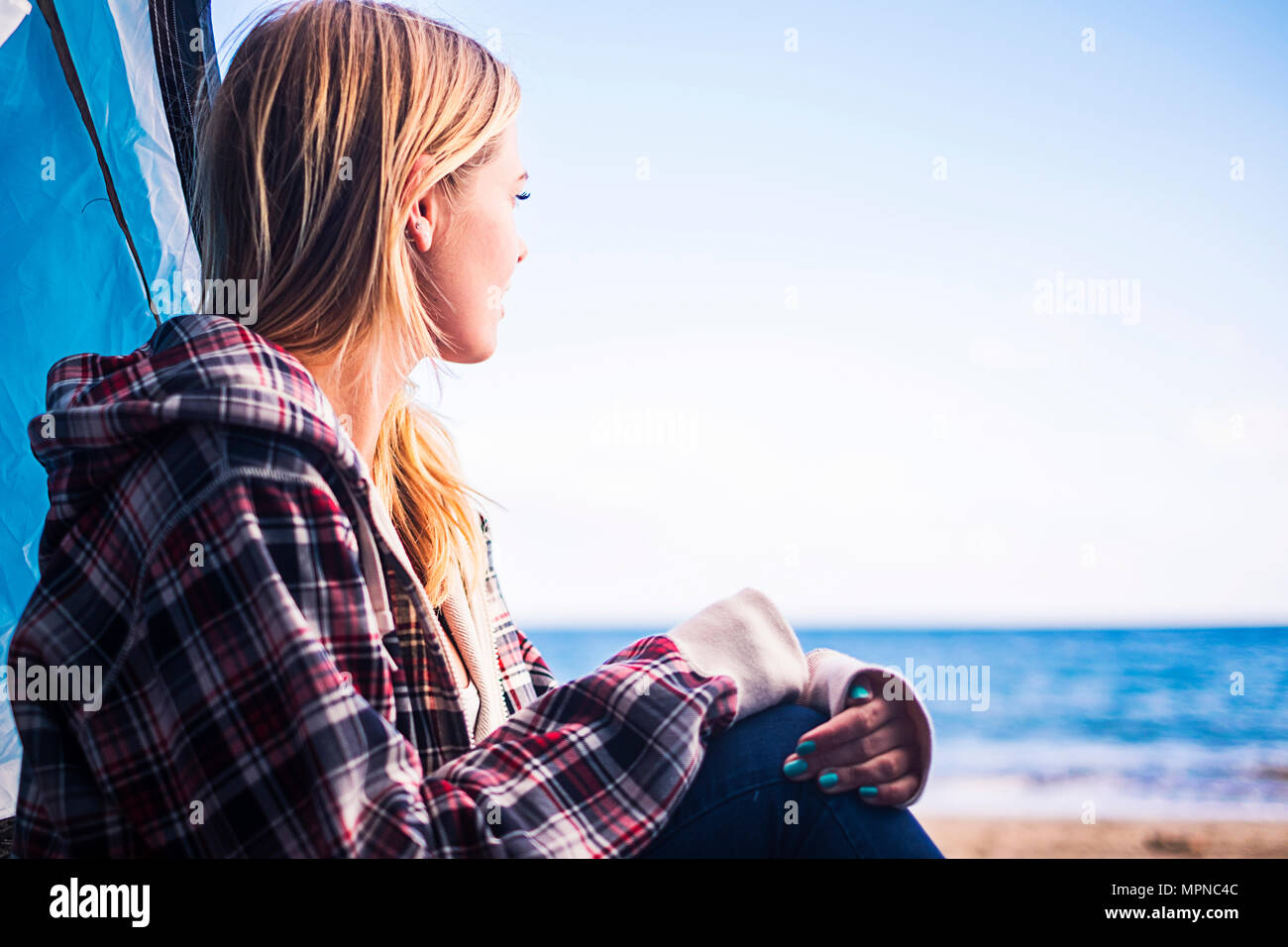 D'autres modes de vie et de vacances concept pour la fille blonde s'asseoir à la recherche à l'océan sur la porte de sa tente. Tenerife locetion. Banque D'Images
