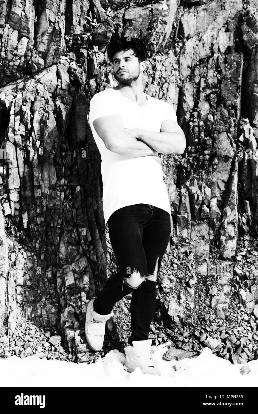 Portrait de beau jeune homme en jeans Vêtements Looking at Camera - Debout contre un mur de brique sur Copy Space Banque D'Images