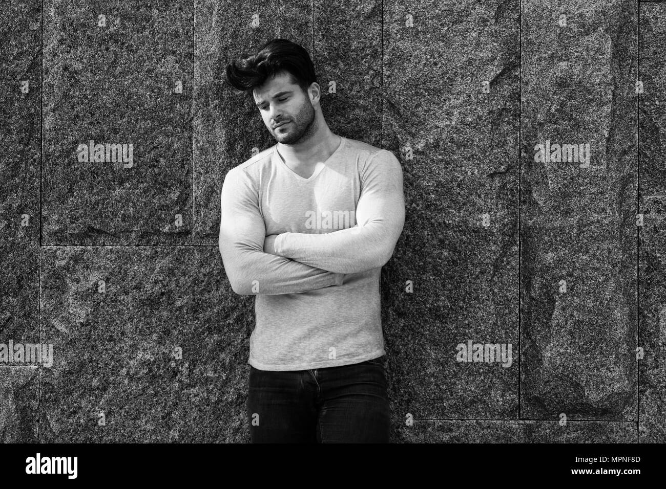 Mode homme cool en jean bleu et permanent à la route - contre un mur de briques sur Copy Space Banque D'Images