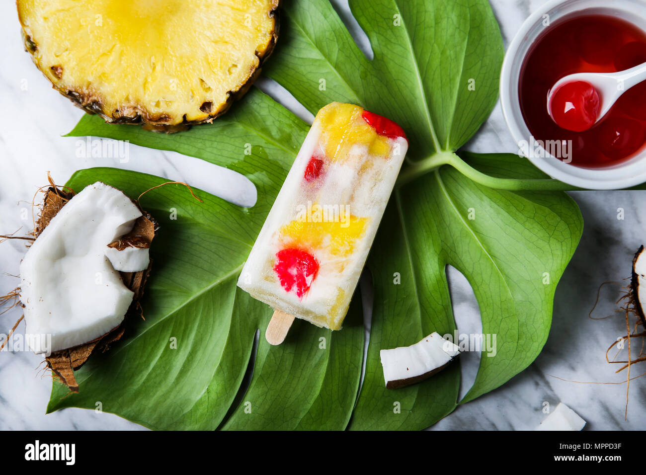 Popsicle Pina Colada avec cerises confites et ananas on leaf Banque D'Images