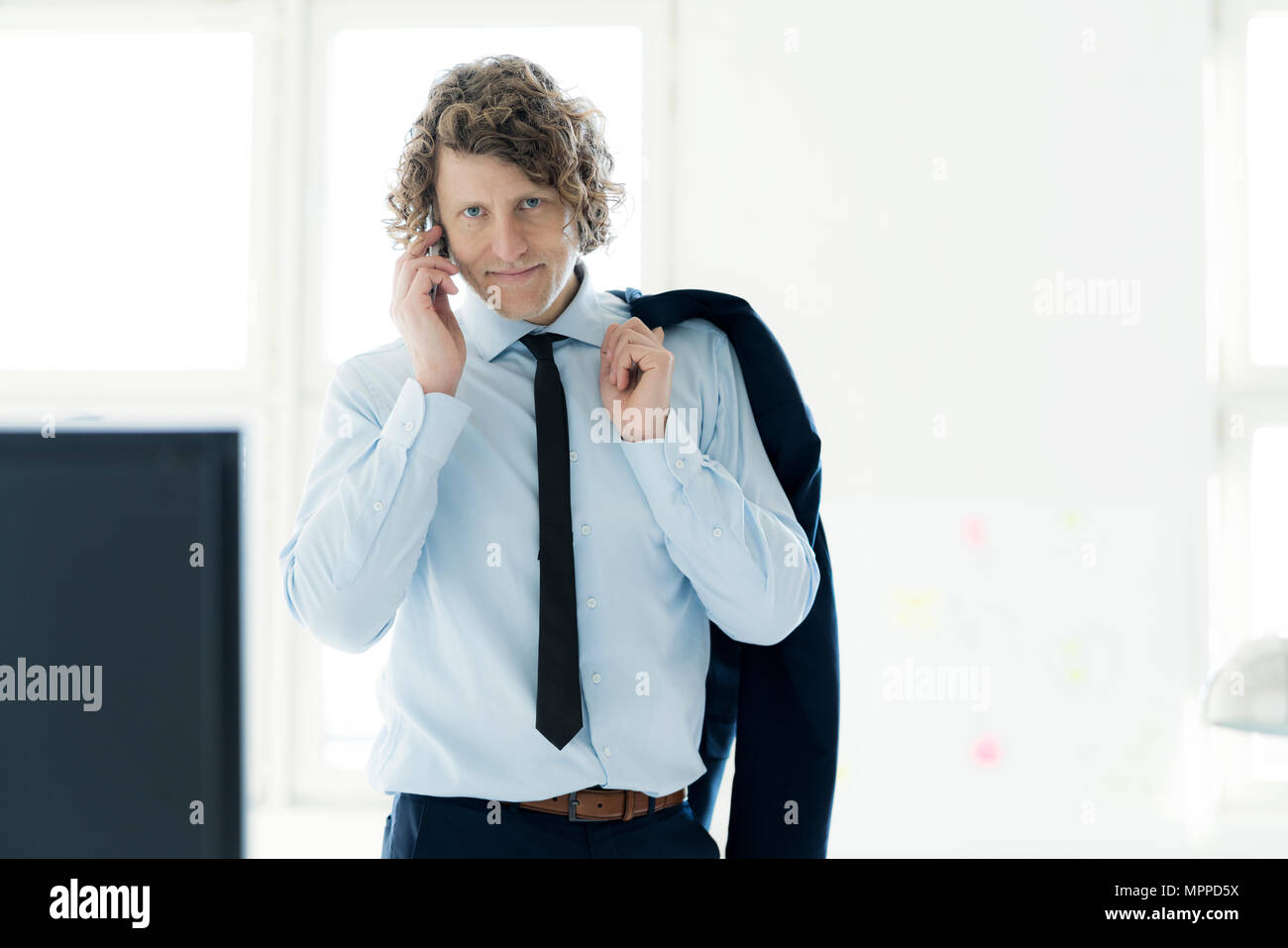 Smart businessman standing in office, à l'aide de mobile phone Banque D'Images Smart businessman standing in office, à l'aide de mobile phone Banque D'Images