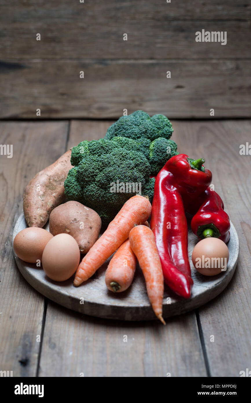 Les aliments biologiques qui contient beaucoup de vitamine A, brocoli, carottes, pommes de terre sucrées, de poivron rouge et d'œufs Banque D'Images