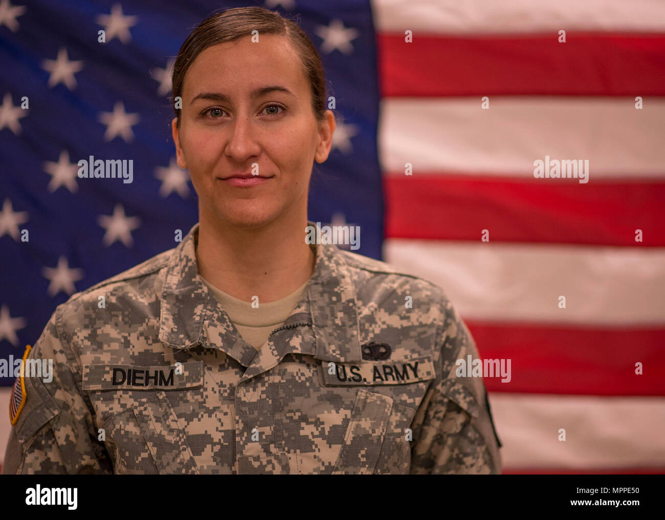 Réserve de l'armée américaine le Cpl. Rachel Diehm, un photographe avec Det. 5, 982e Caméra Combat Co. (aéroportée), de Fort Bragg, N.C., pose devant un drapeau américain avant son déploiement cérémonie à la 335e commande de signal (Théâtre) à East Point, Géorgie, le 7 mars 2017. Le détachement a été de se lancer dans un déploiement de neuf mois pour le Moyen-Orient à l'appui de la Force Opérationnelle Interarmées OIR. (U.S. Réserve de l'armée photo prise par le s.. Ken Scar) Banque D'Images