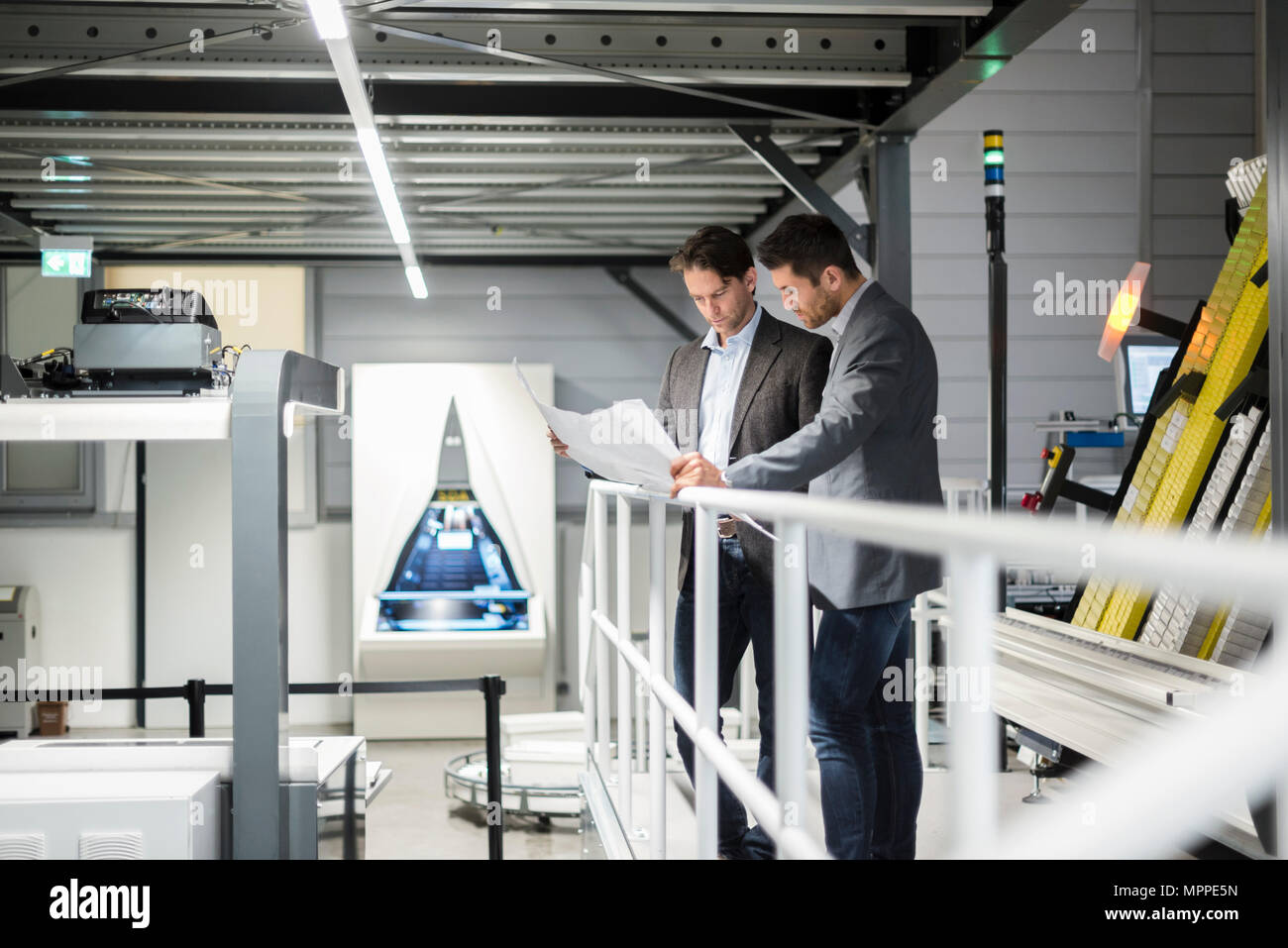 Deux hommes d'affaires à la recherche au plan dans l'usine moderne Banque D'Images
