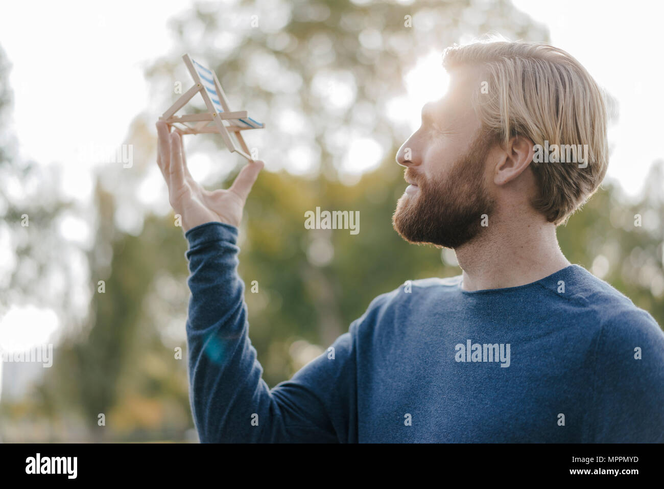 L'homme dans le parc automne à la plage miniature à rêver d'été, chaises longues Banque D'Images