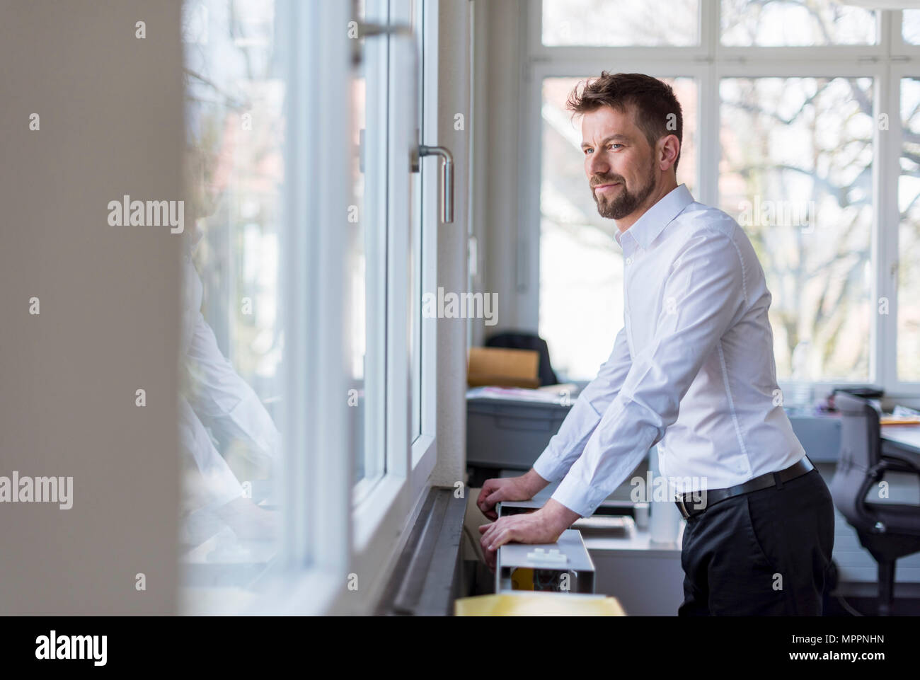 Portrait d'un homme d'affaires prospère stansing dans office, à la fenêtre de Banque D'Images