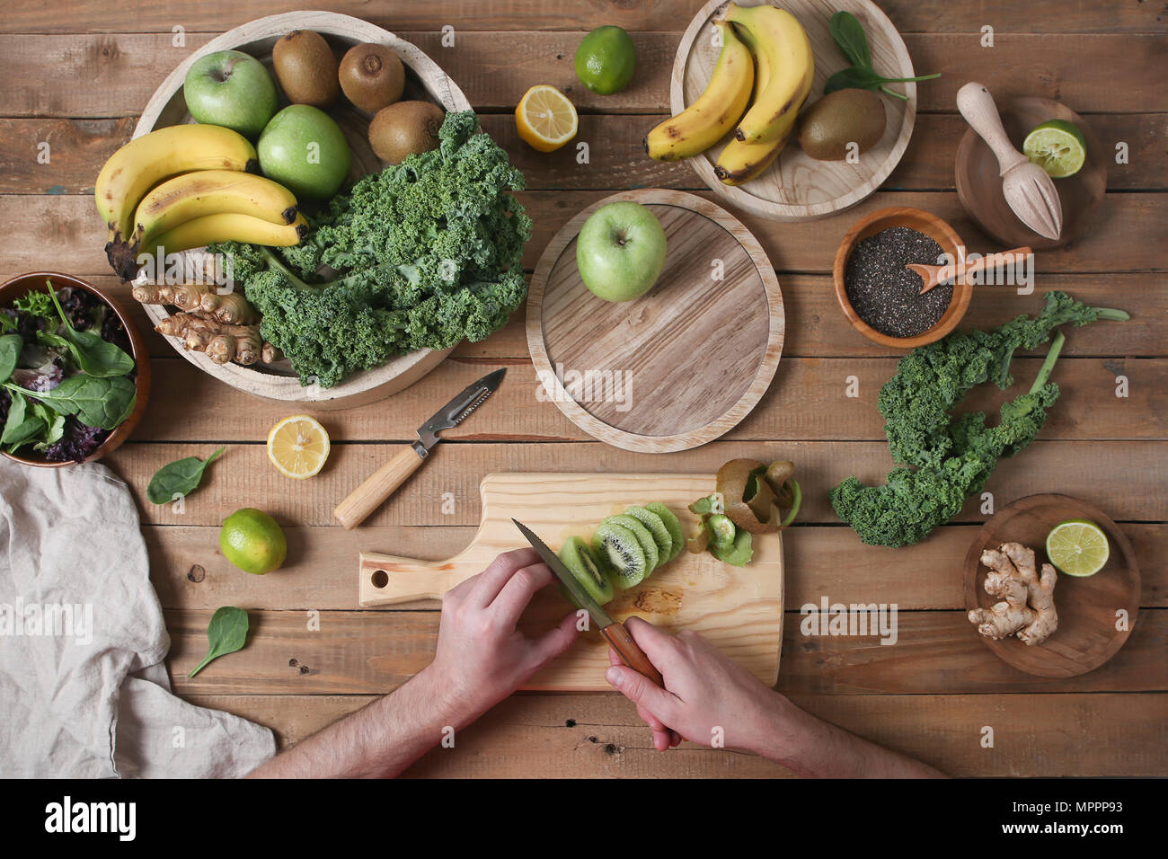 L'homme préparation slicing smoothie vert kiwi Banque D'Images