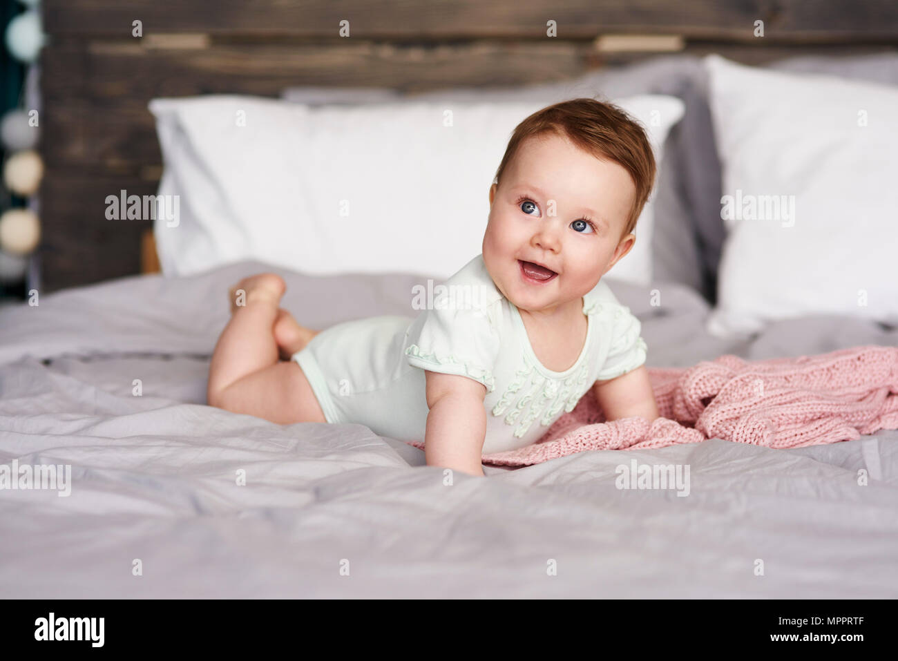 Happy Baby lying on bed at home Banque D'Images