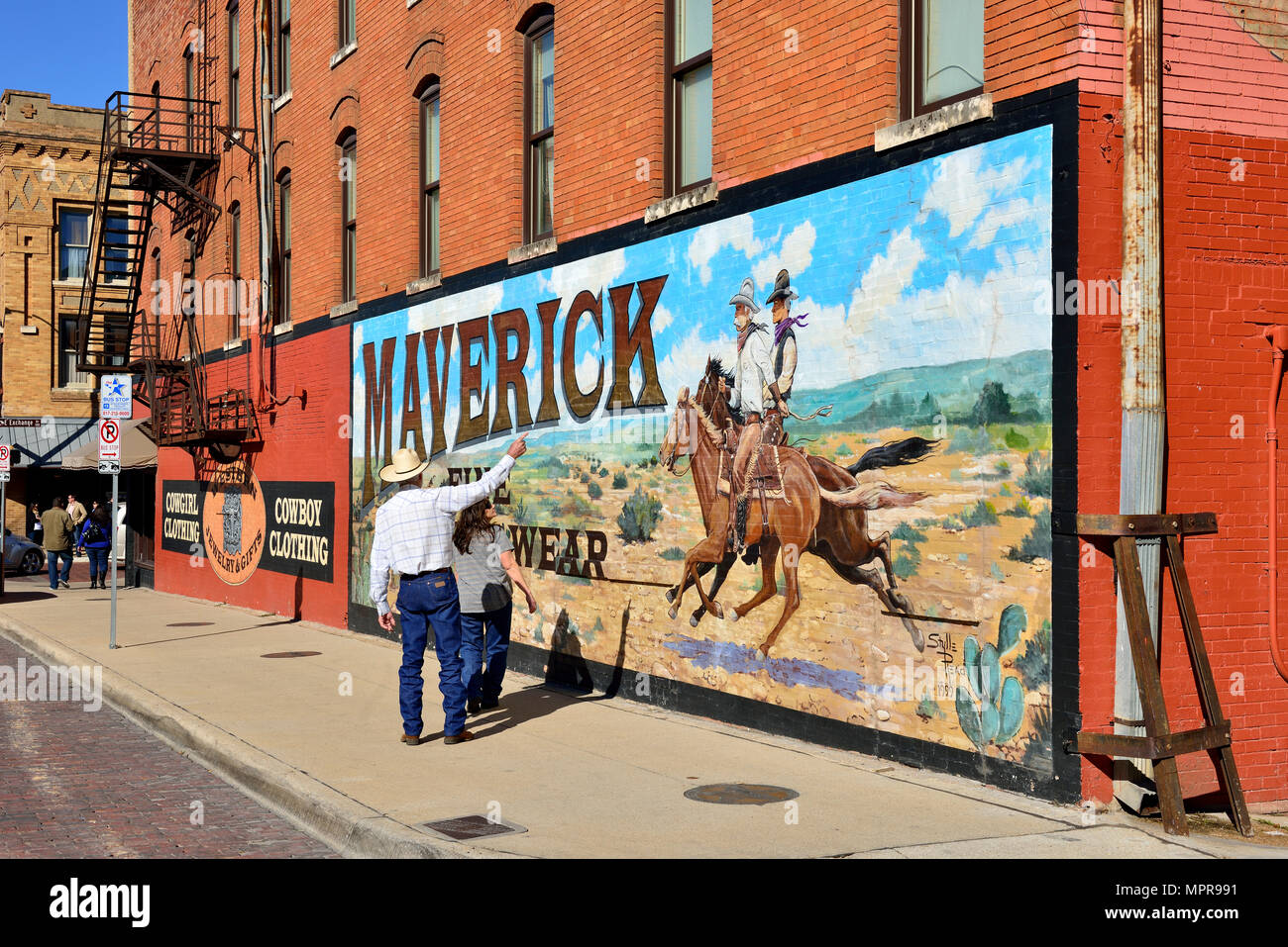 La publicité pour les vêtements occidentaux, peinture murale avec cowboys sur mur de la maison, Stockyards National Historic District, Fort Worth Banque D'Images